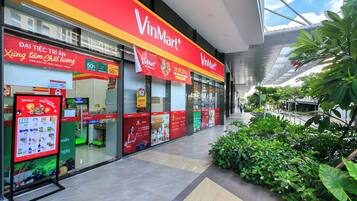 A VinMart store with large promotional banners, a glass facade, and a tiled floor.