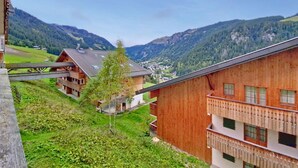A mountain village with traditional wooden buildings, a bridge, and a view of the valley. - Grand Lodge GRA13 SPA & MOUNTAIN 6 Pers. (Châtel)
