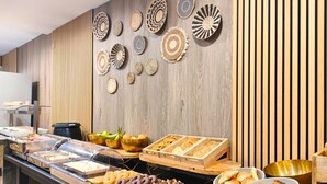 A buffet area with various food items and decorative wall art.