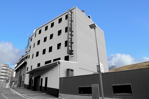 A modern hotel building with a prominent "HOTEL FOCUS" sign, multiple floors, and a parking garage entrance.