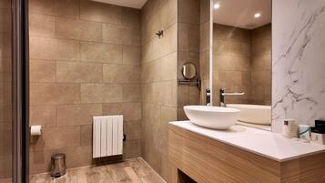 A modern bathroom with a large mirror, a white sink, and a bathtub.