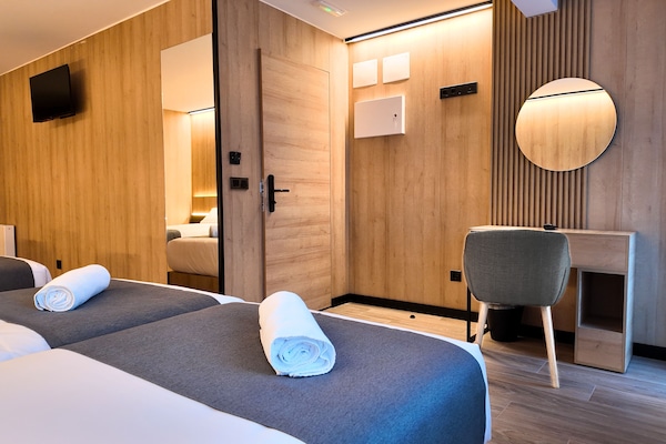 Luxe vierpersoonskamer | Luxe beddengoed, bedden met traagschuimmatras, een bureau