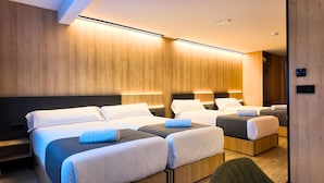 Ein Hotelzimmer mit zwei Betten, Holzwandverkleidung und integrierter Beleuchtung.