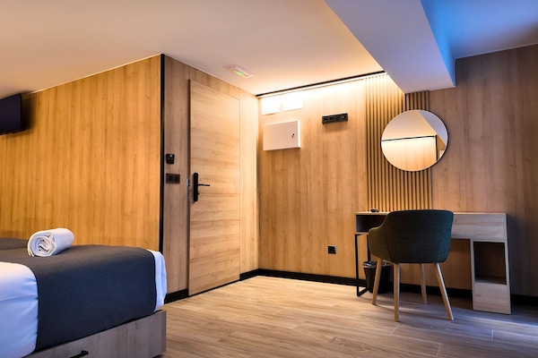 Luxe driepersoonskamer | Luxe beddengoed, bedden met traagschuimmatrassen, een bureau