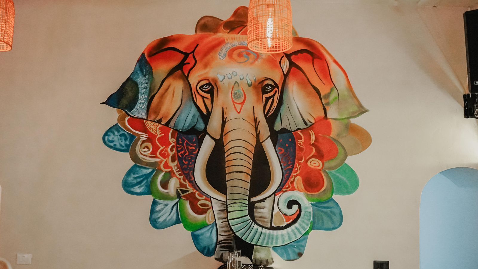 Un mural de un elefante colorido en una pared.