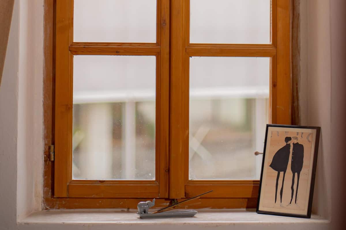 A wooden-framed window with a picture frame on the sill.
