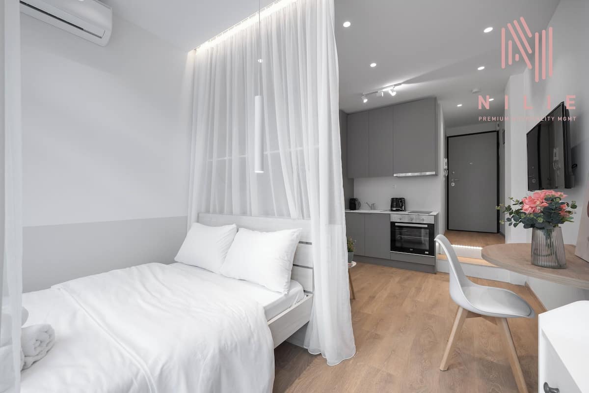 Une chambre d’hôtel moderne équipée d’un lit, d’un coin repas et d’une cuisine.
