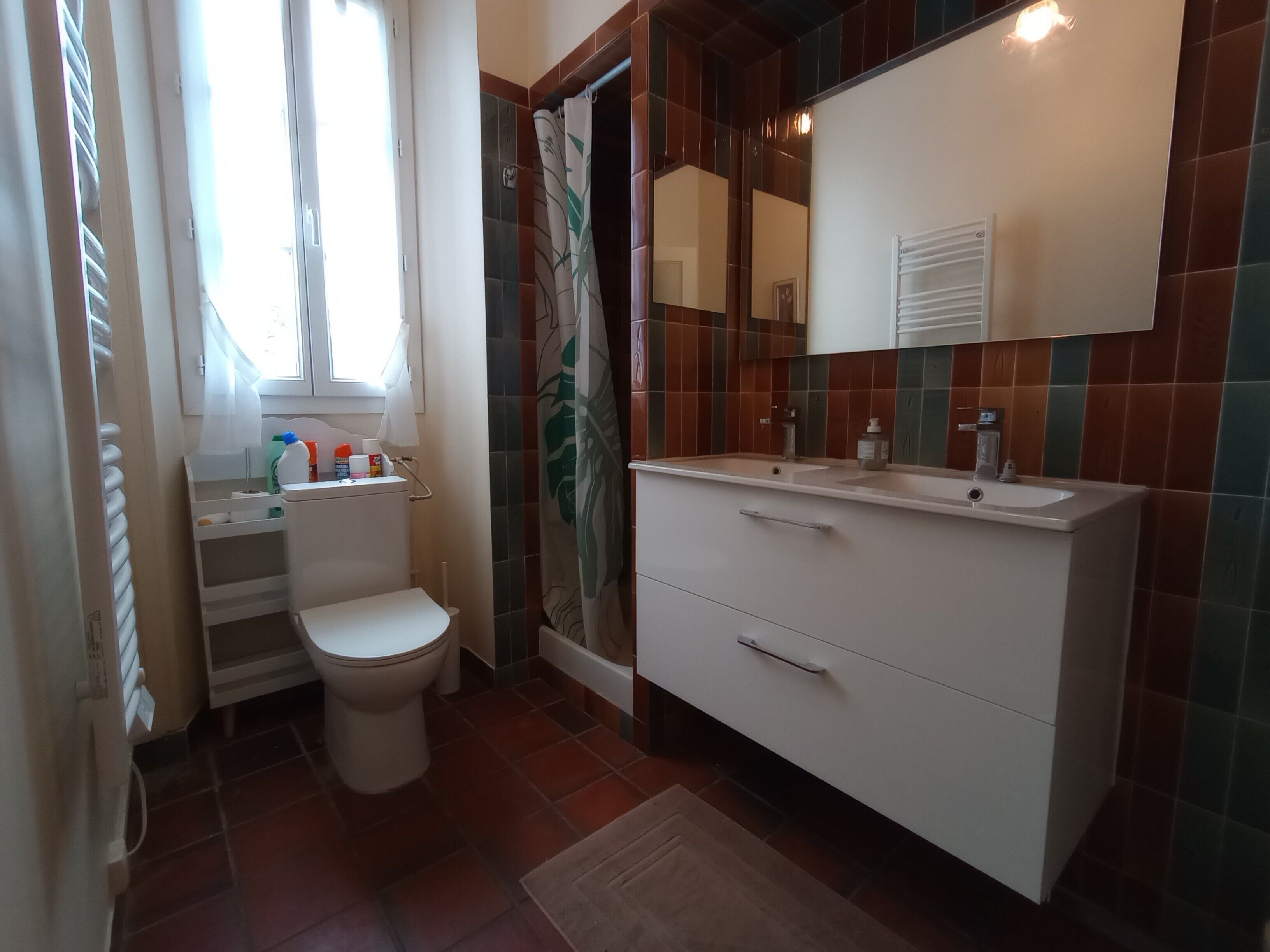 A bathroom with a toilet, sink, and shower.