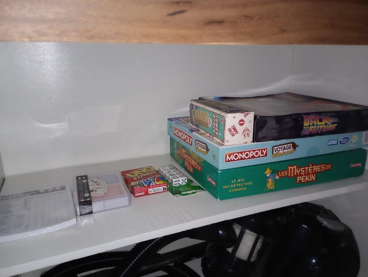 A shelf with various board games including Monopoly, UNO, and others.