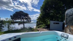 Un bain à remous avec vue sur un lac et des arbres.
