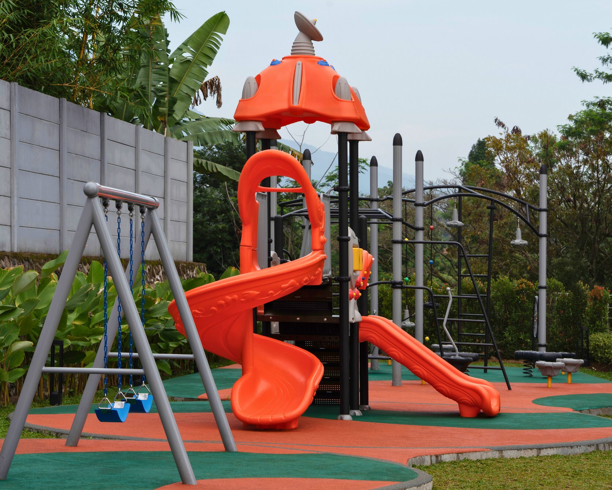 Un parque infantil con tobogán, columpios y estructuras para escalar.