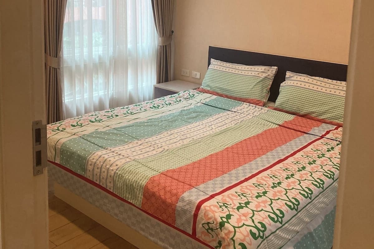 Une chambre à coucher avec un lit, des rideaux et une fenêtre.