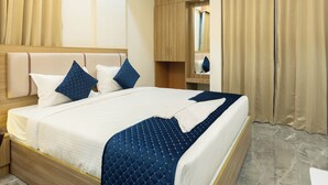 Een moderne hotelkamer met een groot bed, een houten hoofdbord en een marmeren vloer.