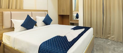 A modern hotel room with a large bed, wooden headboard, and a marble floor.