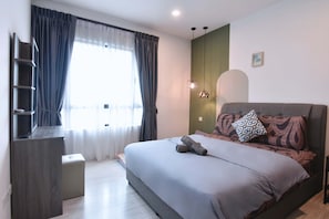 Un dormitorio moderno con cama, mesita de noche y ventana con cortinas.
