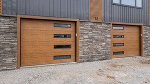 A modern building with two large wooden doors, stone wall, and a gravel driveway. - New Luxury 4 Bed Condo Perfect for Winter Rental (Hampton)