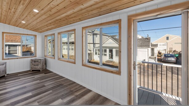 Amplia habitación con techo de madera, ventanas grandes y vista al exterior.