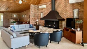 A cozy living room with a fireplace, a sofa, a coffee table, and a TV.