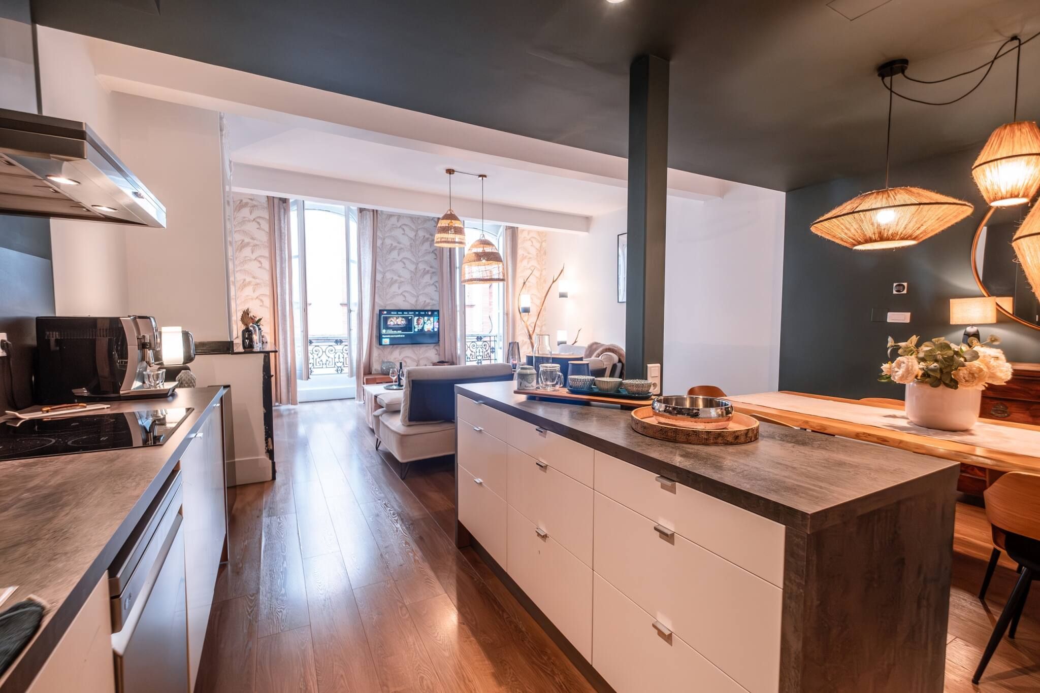 A modern kitchen with a central island, built-in appliances, and pendant lighting.