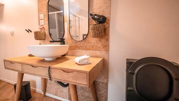 Un bagno con un mobile bagno in legno, un lavandino bianco, uno specchio grande e un asciugamano sul ripiano.