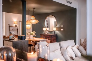 Een moderne woonkamer met een bank, een eettafel en een keuken op de achtergrond.