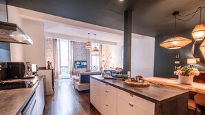 A modern kitchen with a central island, built-in appliances, and pendant lighting.