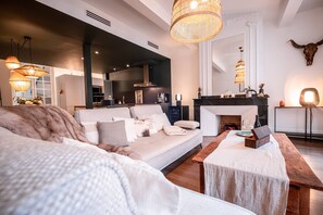 A modern living room with a sofa, a wooden table, and a fireplace.