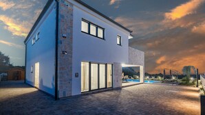 A modern two-story house with a swimming pool, a patio, and a stone facade. - Enchanting Villa North with Pool and Jacuzzi (Krnica)