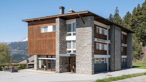 A modern hotel with a stone facade, wooden accents, and a sign for a restaurant.