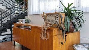 A reception desk with a wooden finish, a potted plant, and a vintage radio.