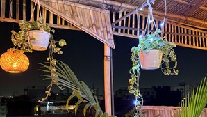 A balcony with hanging plants and a lantern. - Area 369 (Jaipur)