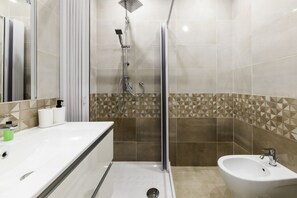 A modern bathroom with a shower, bidet, and sink. - Casa Tofa By Dimorra (NAPOLI)