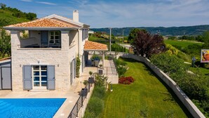 A two-story stone house with a swimming pool, a covered patio, and a view of the surrounding countryside. - Villa with pool in Istria for 8 persons, with a wonderful panoramic view  (Vižinada)