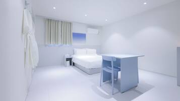 Ein modernes Hotelzimmer mit Bett, Schreibtisch und einem Vorhangfenster.