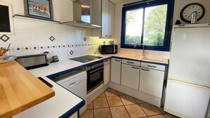 A compact kitchen with white cabinets, a microwave, a toaster, and a sink.