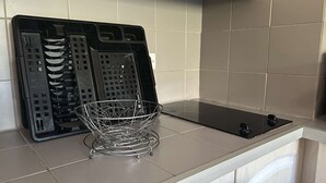 Une cuisine avec un plan de travail noir, un panier en fil de fer et un appareil électroménager noir.