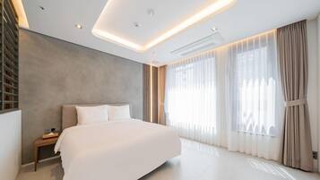 A modern bedroom with a large bed, a bedside table, a built-in shelf, and a large window with curtains.