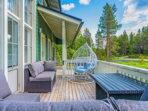 A covered outdoor deck with a hanging chair, a sofa, and a bench. - Rukan tunturituuli by Interhome (Kuusamo)