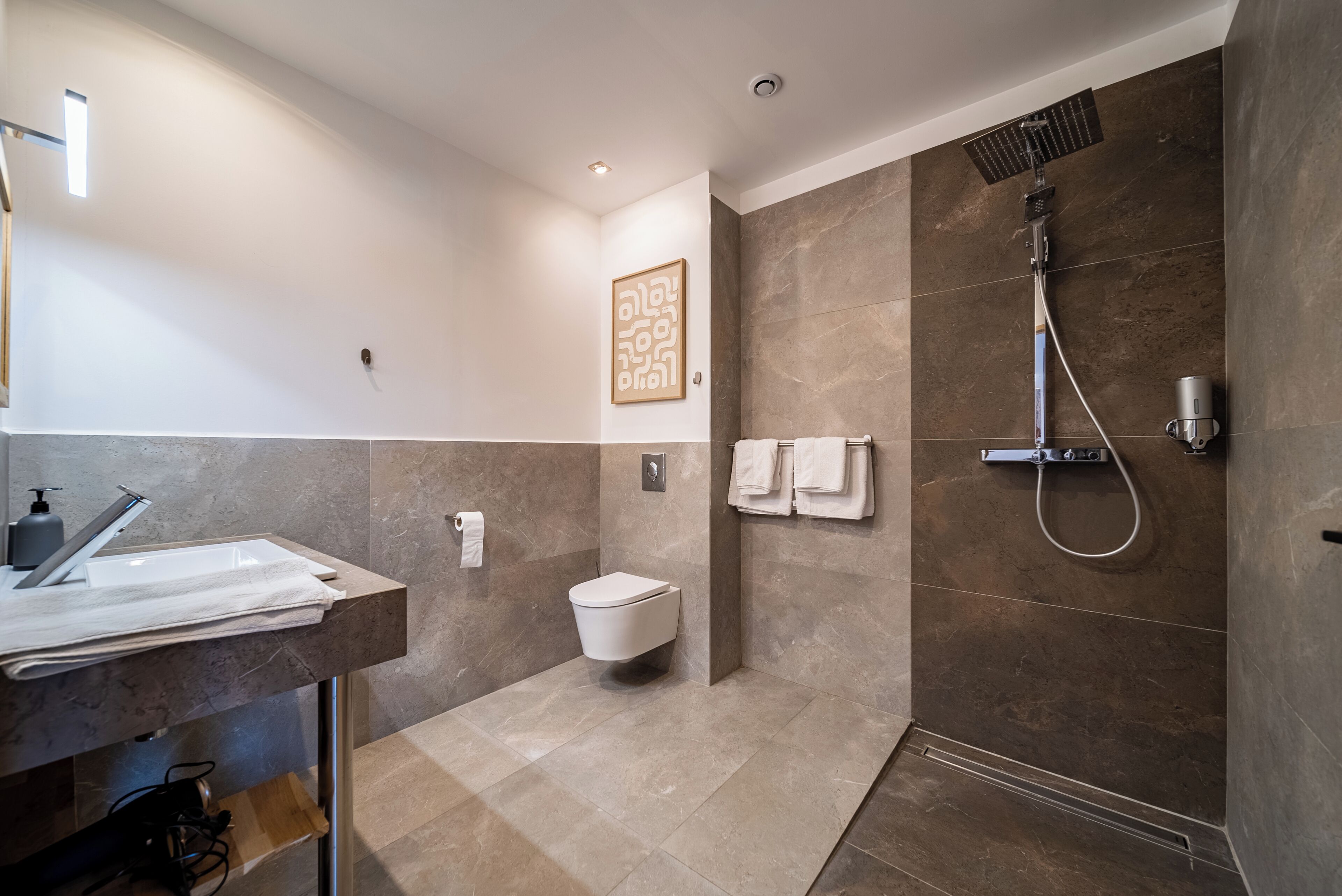 A modern bathroom with a sink, toilet, and shower.