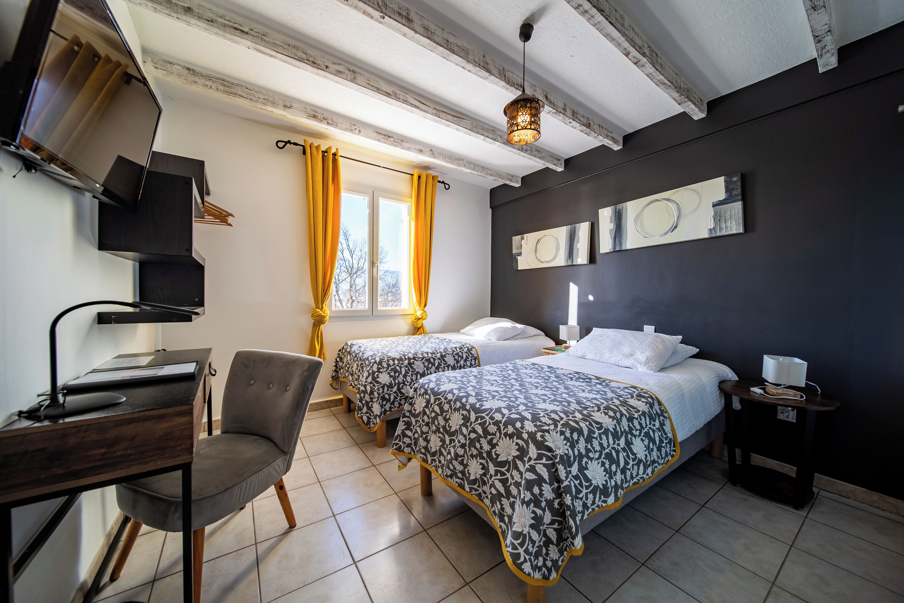 Un dormitorio con dos camas, un escritorio, una silla y un televisor.