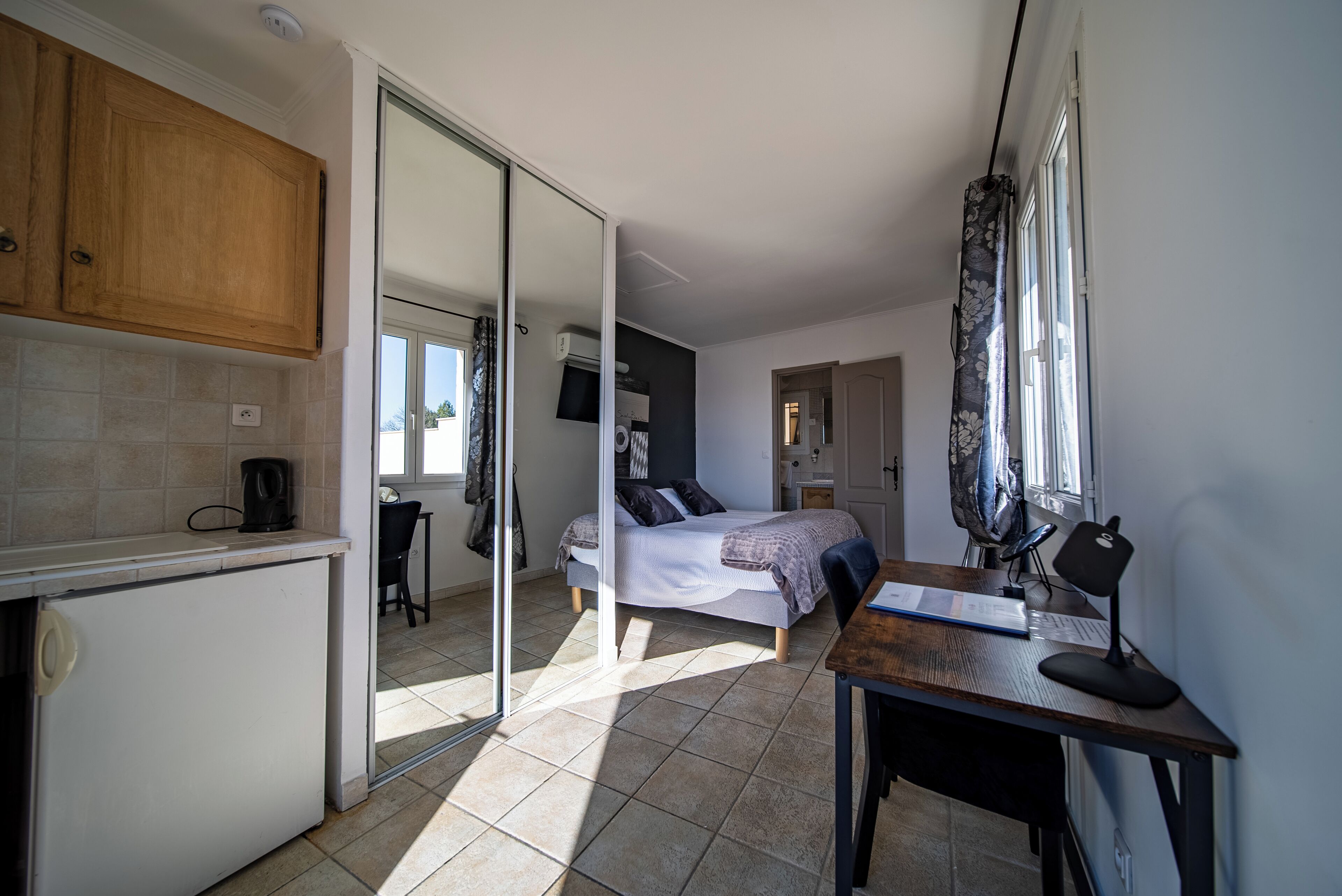 Une chambre à coucher de taille réduite, comprenant un lit, un bureau et une chaise.