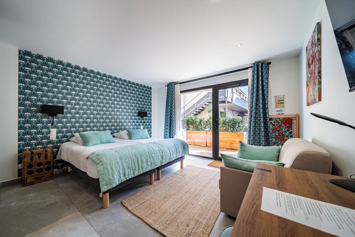Une chambre moderne avec un lit, un bureau et une vue sur l’extérieur.