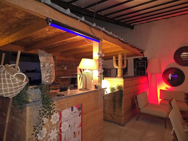 Un interior acogedor con mostrador de madera, plantas decorativas y una escultura de cactus.
