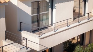 A modern building with a tiled roof, large windows, and a balcony with a metal railing. - Les Loges du Luberon (Cabrieres-d'Avignon)
