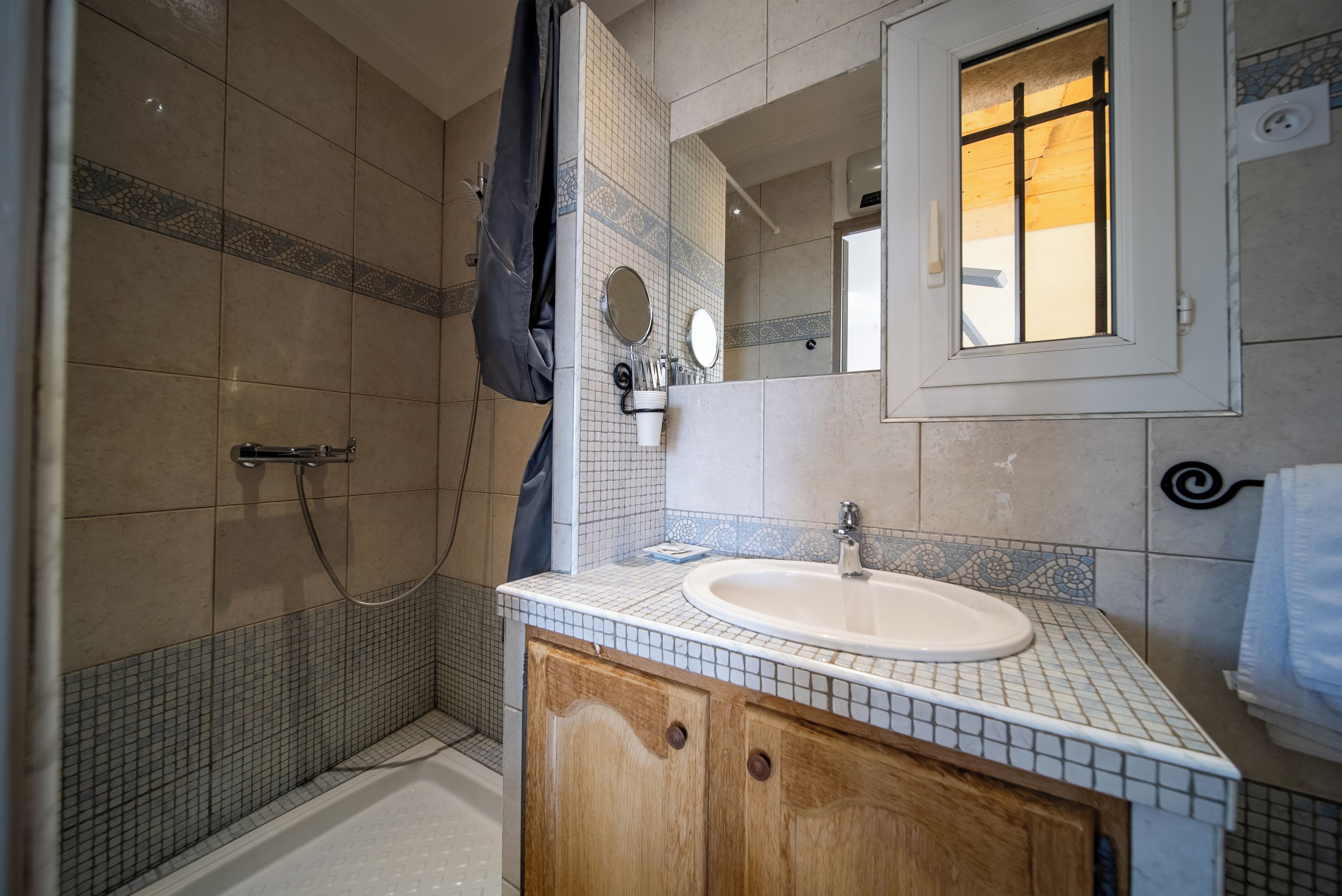 Ein Badezimmer mit Dusche, Waschbecken und Spiegel.