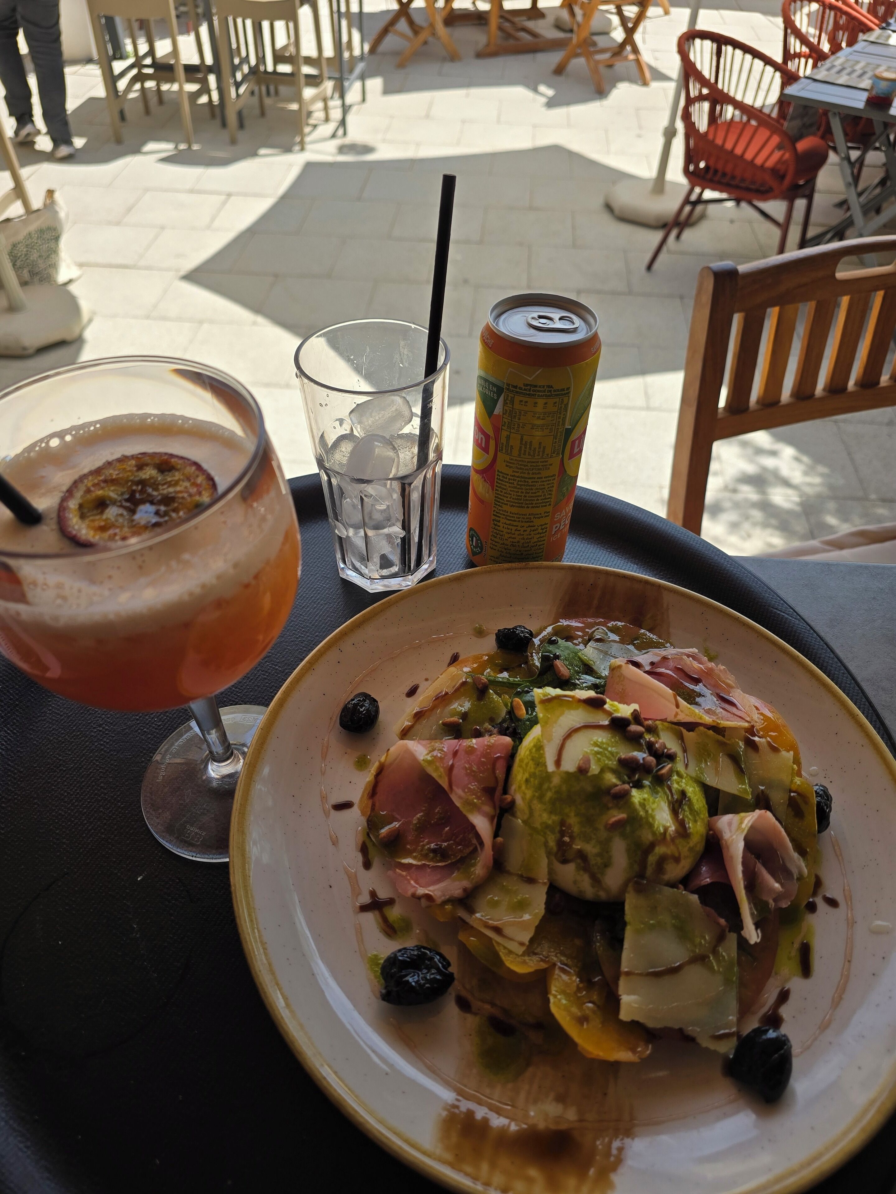 A table with a meal, a drink, and a beverage can.