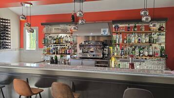 A bar area with a wine rack, shelves of bottles, and a coffee machine.