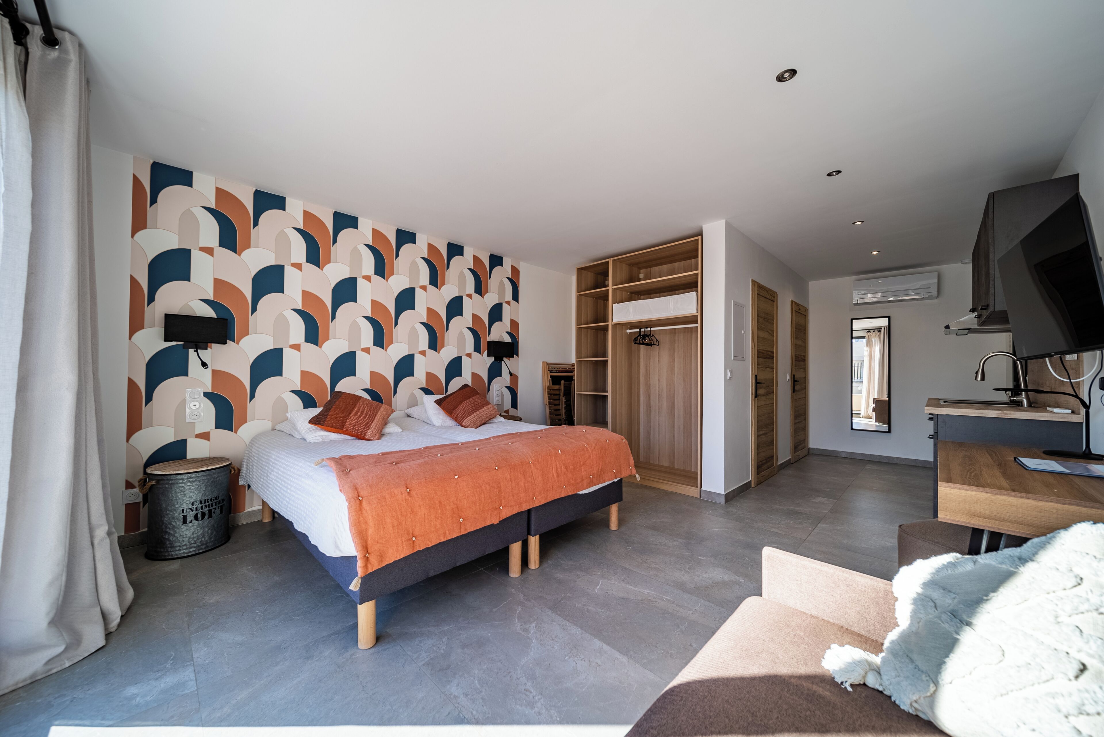 Un dormitorio moderno con cama, escritorio y armario.