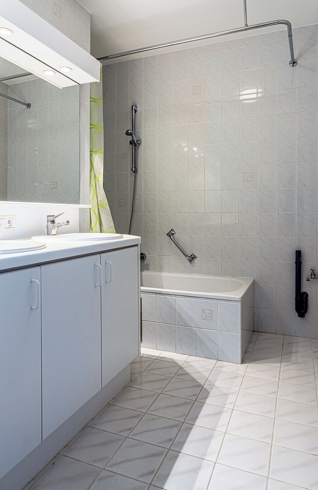 A modern bathroom with a bathtub, a shower, and a vanity with a mirror.