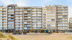 Un hôtel à plusieurs étages doté de balcons, situé en bord de mer et offrant des espaces de détente en plein air.